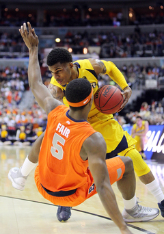 Vander Blue #13 of the Marquette Golden Eagles drives to the basket against C.J. Fair #5.