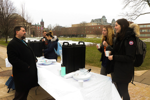 Jonathan Hoster, an adviser for the Traditions Commission, hands out hot chocolate on the Quad. The Winter Carnival has been a Syracuse staple for almost 100 years, providing different activities for students to destress before midterm exams.