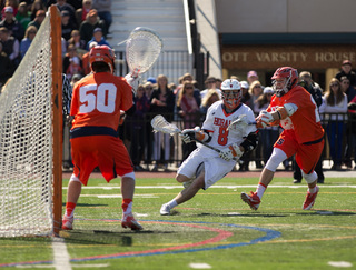 Hobart's Zach Reed dodges past Jordan Evans toward the cage, where Dominic Lamolinara awaits.