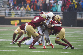 Boston College defenders gang tackle against Syracuse on Saturday.