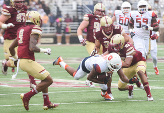 Syracuse wide receiver Steve Ishmael falls to the turf while several Eagles defenders surround him.