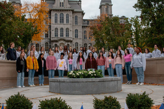 The SU Mandarins, an a cappella group, hold hands as they perform. The group closed out the candlelight vigil with a rendition of “I’ll be Seeing You” by Billie Holiday.